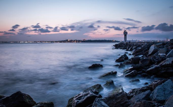 Lighthouse in distance passed rocks